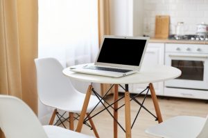 table-ronde-blanche-ordinateur-portable-ecran-blanc-pour-publicite-telephone-intelligent-dessus-espace-travail-pour-pigiste-maison-dans-cuisine-lumineuse-pres-fenetre